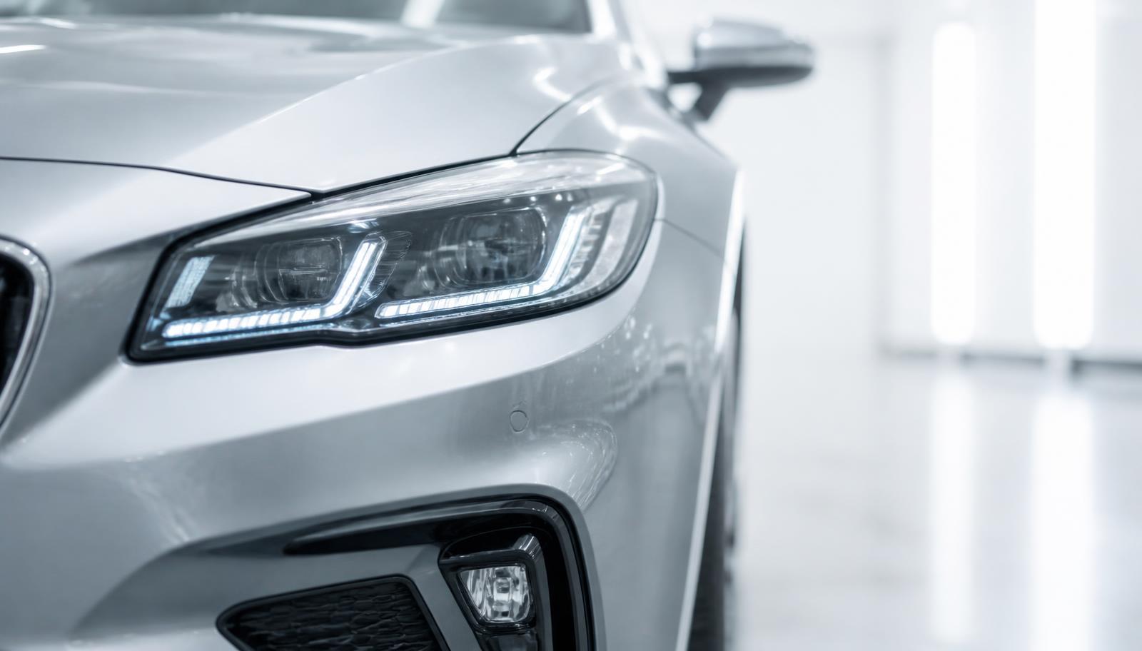LED headlight and fog light on a silver car finished with clear protective film